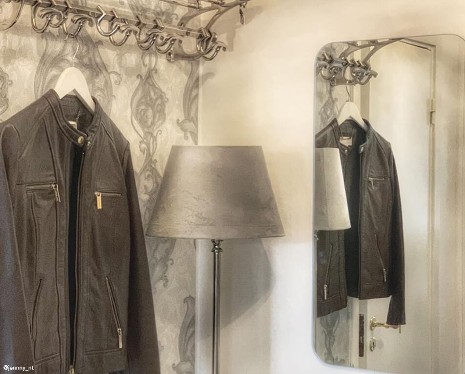 Zařízení předsíně – kovová věšáková police, obdélníkové zrcadlo a šedá lampa